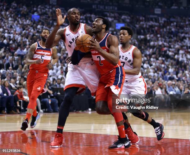 John Wall of the Washington Wizards drives to the basket as Serge Ibaka of the Toronto Raptors defends during the first half of Game Five in Round...