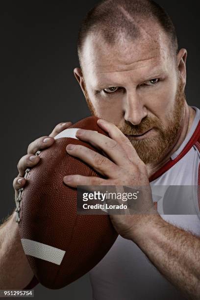 bearded aggressive redhead adult man flag football player holding a football - quarterback stock pictures, royalty-free photos & images
