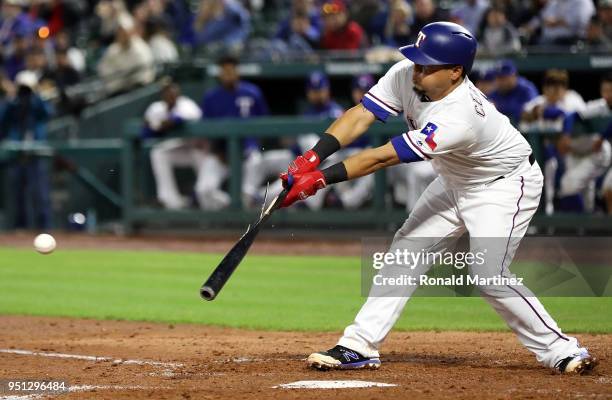 Juan Centeno of the Texas Rangers hits into a fielders choice scoring one run in the fourth inning against the Oakland Athletics at Globe Life Park...