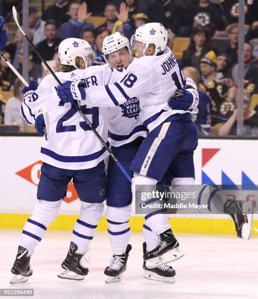 Travis Dermott of the Toronto Maple Leafs, center, celebrates with William Nylander and Andreas Johnsson after scoring a goal against the Boston...