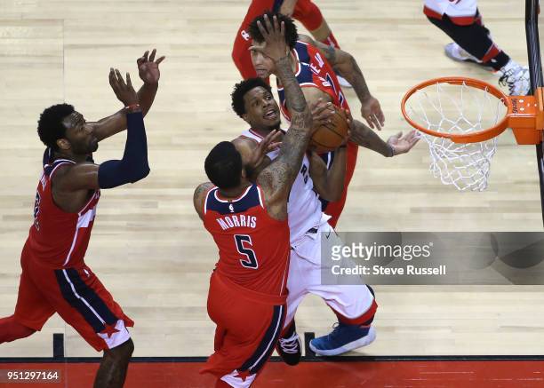 Toronto Raptors guard Kyle Lowry draws a crowd under the basket as the Toronto Raptors win game five of their first round of the NBA playoffs against...