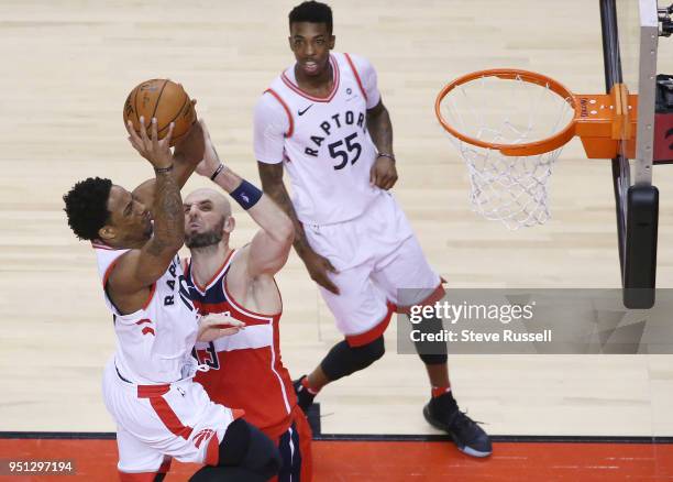 Toronto Raptors guard DeMar DeRozan gets the ball over Washington Wizards center Marcin Gortat as the Toronto Raptors win game five of their first...