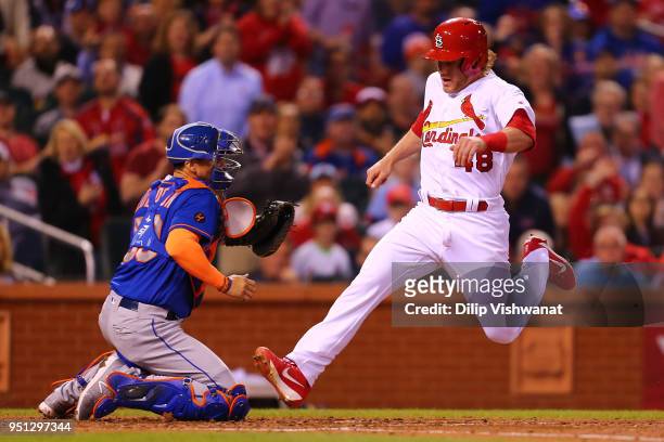 Harrison Bader of the St. Louis Cardinals scores a run against Jose Lobaton of the New York Mets in the third inning at Busch Stadium on April 25,...