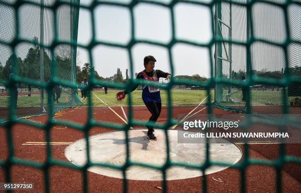 This photo taken on April 25, 2018 shows a woman in the 65-70 age category competing in the discus throw during Thailand's first national Elderly...