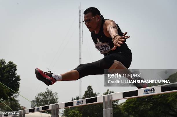 This photo taken on April 25, 2018 shows a man in the 65-70 age category competing in the 100-metre hurdles during Thailand's first national Elderly...