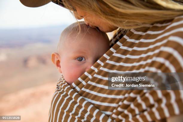 a young mom and her baby - babytrage stock-fotos und bilder