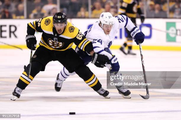 Brad Marchand of the Boston Bruins and Kasperi Kapanen of the Toronto Maple Leafs battle for control of the puck during the second period of Game...