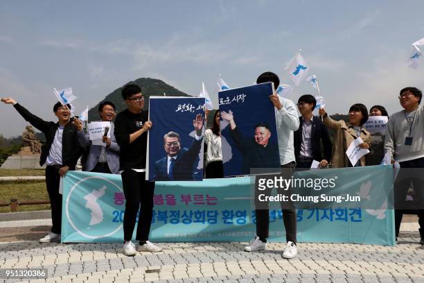 South Koreans hold up placards of South Korean President Moon Jae-In and North Korean leader Kim Jong-Un during a rally welcoming the planned Inter...