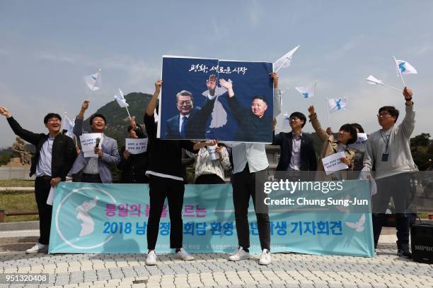 South Koreans hold up placards of South Korean President Moon Jae-In and North Korean leader Kim Jong-Un during a rally welcoming the planned Inter...