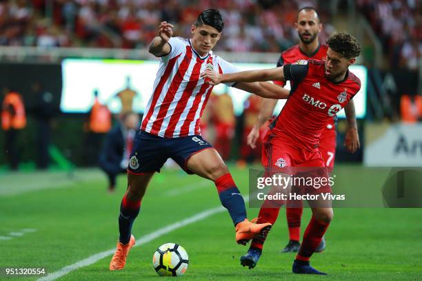 Alan Pulido of Chivas struggles for the ball with Jonathan Osorio of Toronto FC during the second leg match of the final between Chivas and Toronto...