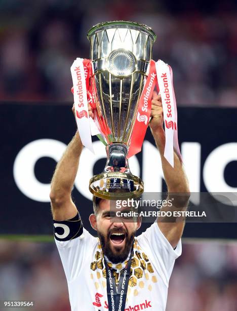Mexico's Guadalajara Miguel Basulto holds the trophy following victory over Canada's Toronto FC in their final second leg football match of the...