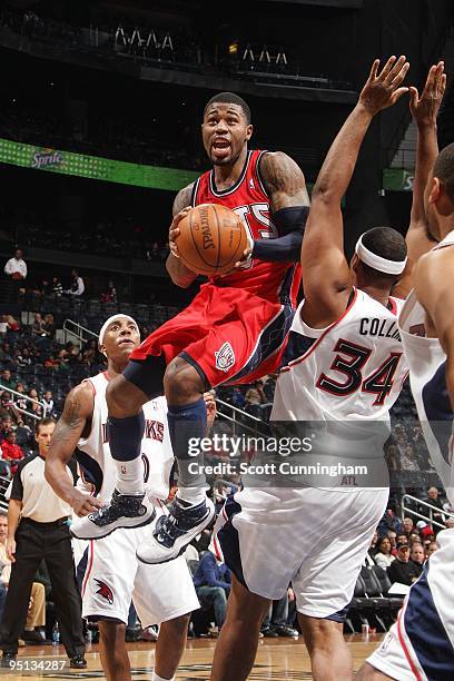 Terrence Williams of the New Jersey Nets goes up for a shot against Jason Collins of the Atlanta Hawks during the game at Philips Arena on December...