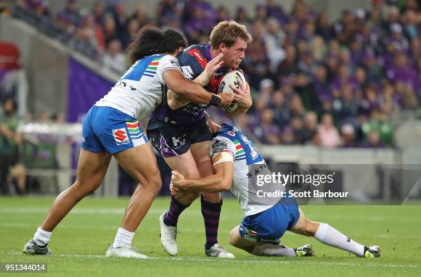 Tim Glasby of the Melbourne Storm is tackled during the round eight NRL match between the Melbourne Storm and New Zealand Warriors at AAMI Park on...
