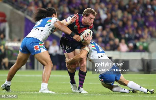 Tim Glasby of the Melbourne Storm is tackled during the round eight NRL match between the Melbourne Storm and New Zealand Warriors at AAMI Park on...