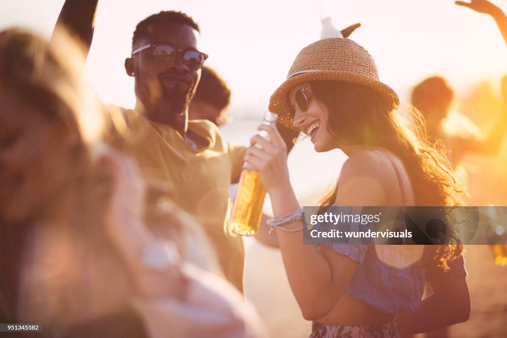 Vrienden van de jonge multi-etnische hipster dansen op zomer strand partij