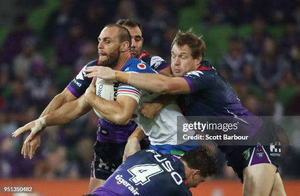 Simon Mannering of the Warriors is tackled by Tim Glasby of the Melbourne Storm and Cameron Smith of the Melbourne Storm during the round eight NRL...