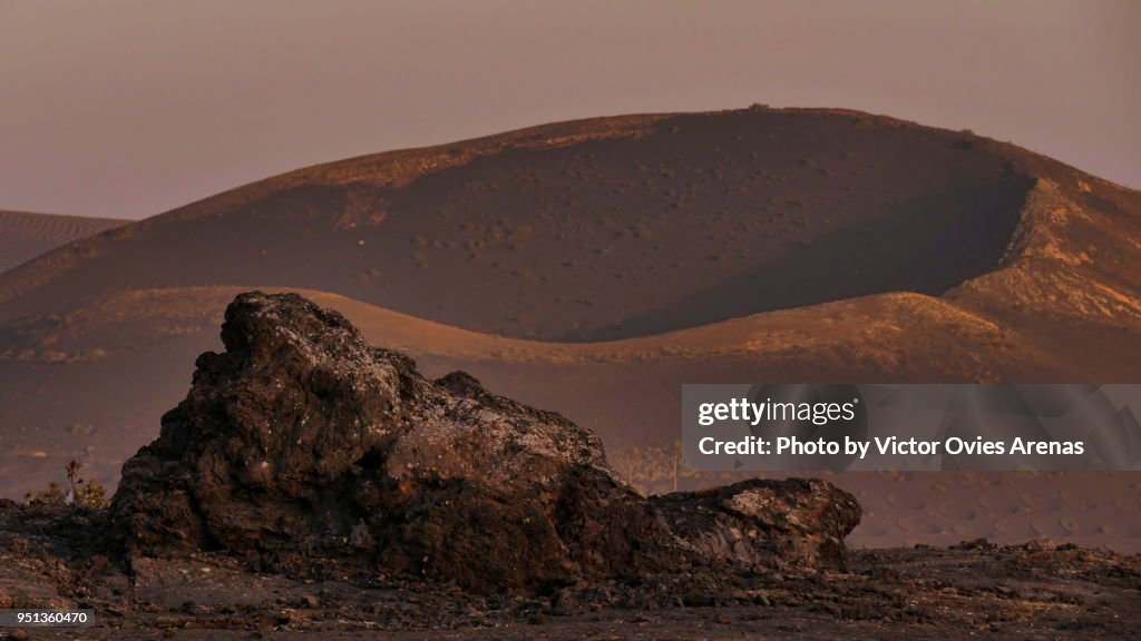 Old volcano crater in la Geria at sunset in Lanzarote, Canary Islands, Spain