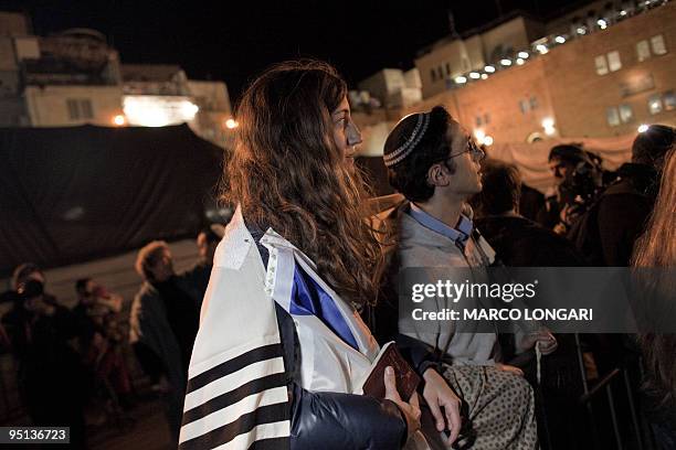 Jewish woman wears a prayer shawl, worn customarily by men only, at the end of a prayer service at the Western Wall Plaza held by the "Women at the...