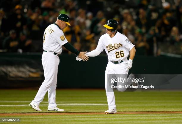 Matt Chapman of the Oakland Athletics is congratulated by Third Base Coach Matt Williams while running the bases after hitting a home run during the...