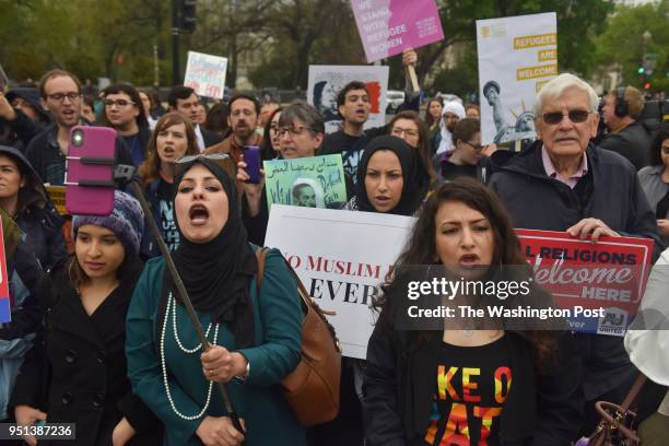 Demonstrators against Donald Trump's Muslim travel ban gather outside the United States Supreme Court as the court hears a case involving the travel...