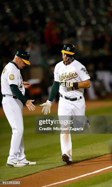 Chad Pinder of the Oakland Athletics is congratulated by Third Base Coach Matt Williams while running the bases after hitting a home run during the...