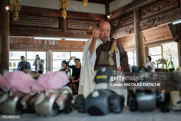 Kofukuji temple chief priest Bungen Oi offers a prayer for Sony's pet robot AIBOs displayed on an altar prior to hold the robots' funeral at the...