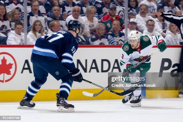 Charlie Coyle of the Minnesota Wild follows the play down the ice as Tyler Myers of the Winnipeg Jets defends during first period action in Game Five...