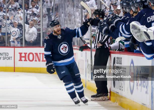 Bryan Little of the Winnipeg Jets celebrates his first period goal against the Minnesota Wild with teammates at the bench in Game Five of the Western...