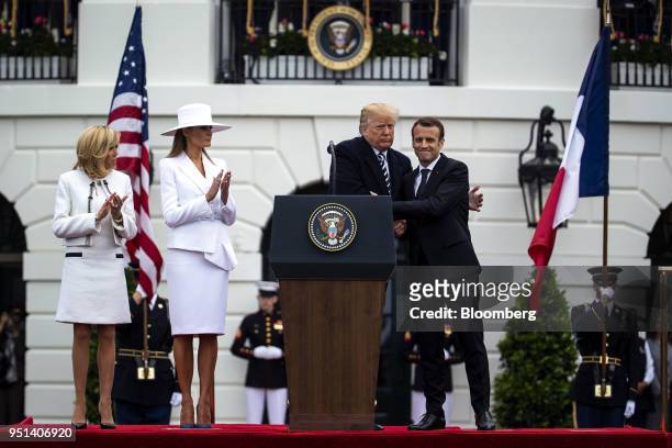 President Donald Trump, center, hugs Emmanuel Macron, France's president, right, while Brigitte Macron, France's first lady, from left, and U.S....