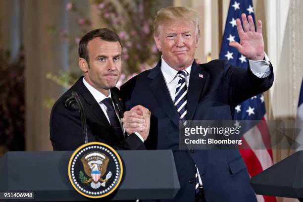 President Donald Trump waves while embracing Emmanuel Macron, France's president, left, at a news conference in the East Room of the White House...
