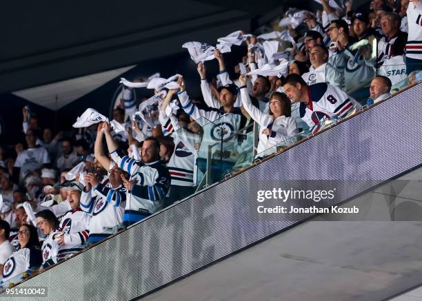 Winnipeg Jets fans clad all in white wave towels as they cheer the team on during first period action against the Minnesota Wild in Game Five of the...