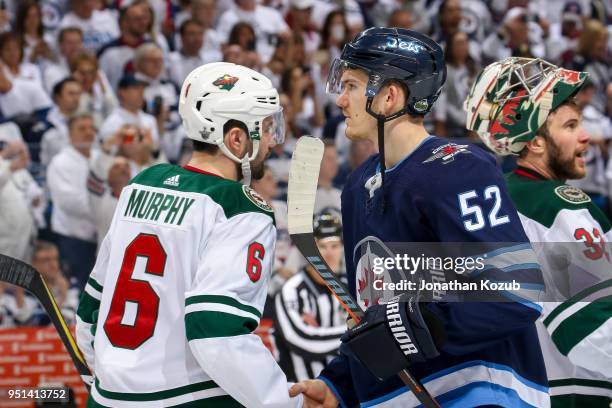 Jack Roslovic of the Winnipeg Jets shakes hands with Ryan Murphy of the Minnesota Wild in the traditional handshake line following a 5-0 victory in...