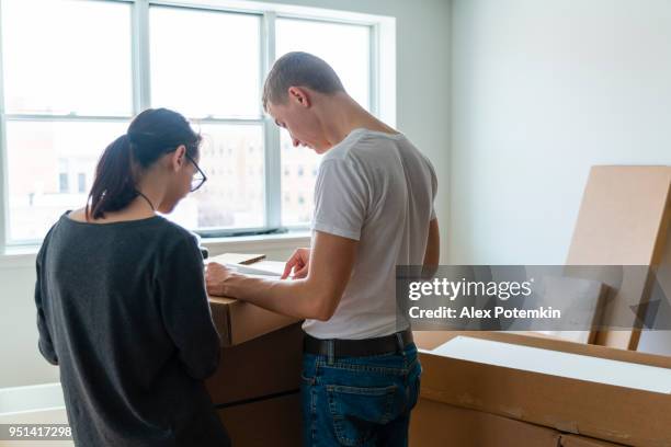 the family moving in to the new apartment. the young 30 years old man and teenager girl unboxing and assembling furniture. - 18 19 years stock pictures, royalty-free photos & images