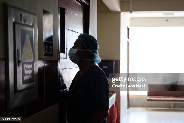Member of the medical team looks on as surgeons work to remove the cataract from Obdulia, aged 60, at the IRO on April 20, 2018 in Trujillo, Peru....