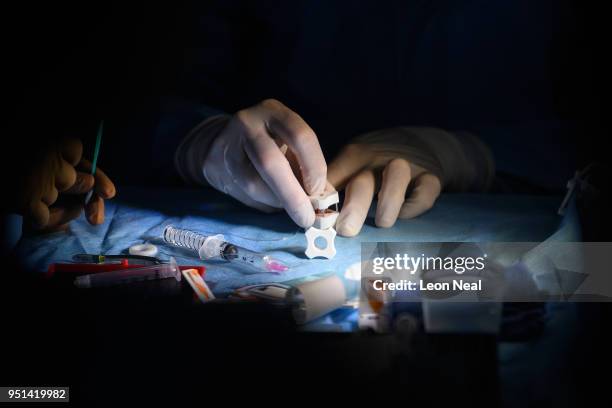 Dr Mark Mannis separates the cornea from a donor rim using a trephine tool during a cornea transplant operation on Reis-Buckler syndrome patient...