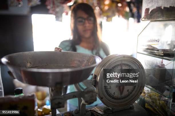 Reis-Buckler syndrome patient Diana, aged 17, stands with the weighing scales she struggles to read when working in the family store on April 19,...