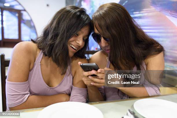 Reis-Buckler syndrome patient Diana, aged 17, jokes with her friend Erika as they enjoy a meal in a restaurant on April 23, 2018 in Trujillo, Peru....