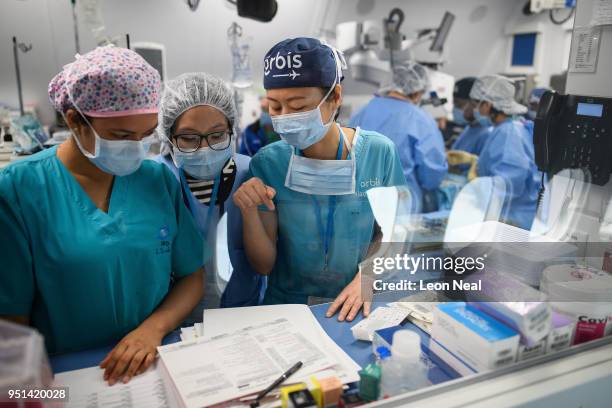 Three nurses discuss the operation as a surgical procedure takes place onboard the Orbis Flying Eye Hospital on April 17, 2018 in Trujillo, Peru....