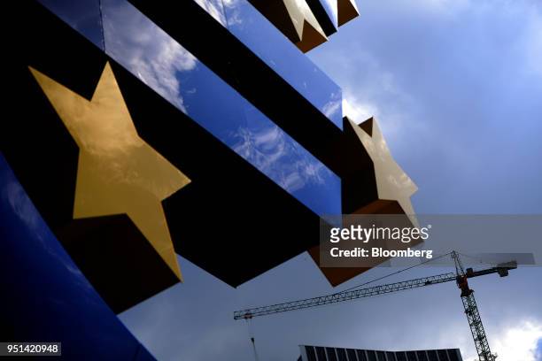 The euro sign sculpture stands in front of a construction crane in Frankfurt, Germany, on Wednesday, April 25, 2018. About 8,000 additional jobs may...