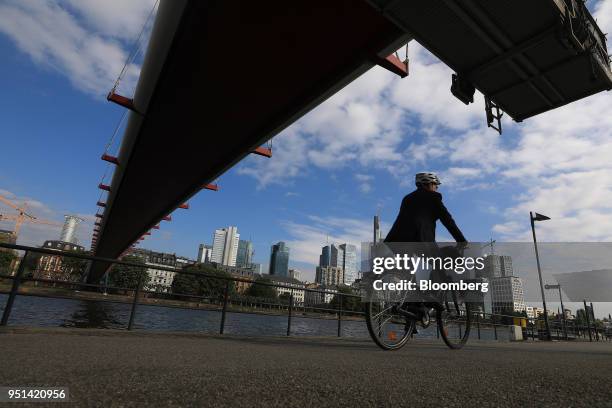 Cyclist passes under a bridge spanning the River Main as skyscrapers stand beyond in Frankfurt, Germany, on Wednesday, April 25, 2018. About 8,000...