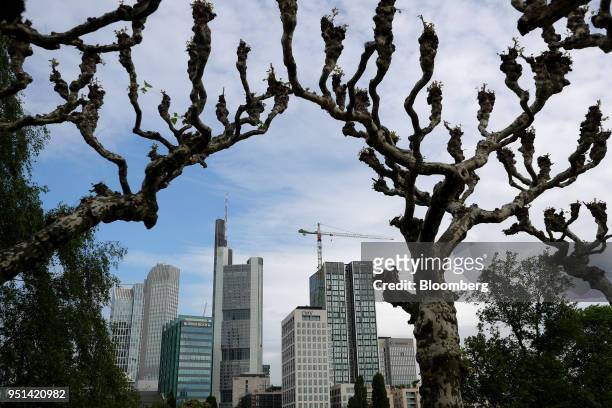 Skyscrapers and a construction crane stand framed by trees in Frankfurt, Germany on Wednesday, April 25, 2018. About 8,000 additional jobs may be...