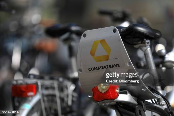 The Commerzbank AG logo sits on the back of a rental bike in Frankfurt, Germany, on Wednesday, April 25, 2018. About 8,000 additional jobs may be...