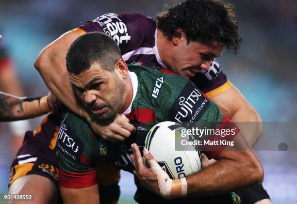 Greg Inglis of the Rabbitohs is tackled by James Roberts of the Broncos in the NRL round eight match between the South Sydney Rabbitohs and the...