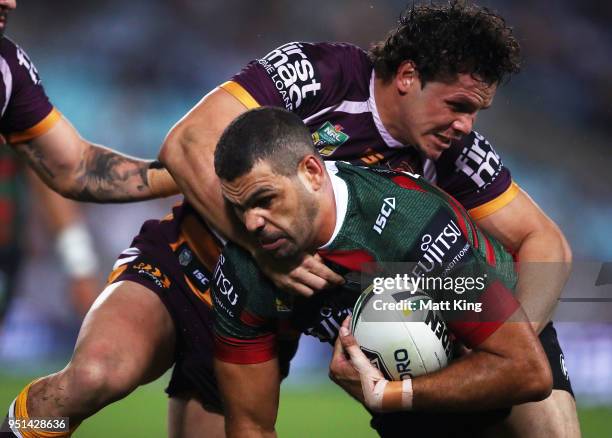 Greg Inglis of the Rabbitohs is tackled by James Roberts of the Broncos in the NRL round eight match between the South Sydney Rabbitohs and the...