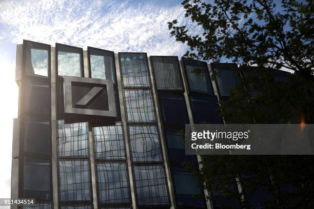 The Deutsche Bank AG logo sits on an office building in Frankfurt, Germany, on Wednesday, April 25, 2018. Germanys largest lender will scale back...