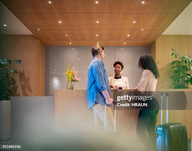 par hablar con el recepcionista en el vestíbulo del hotel - receptionist fotografías e imágenes de stock