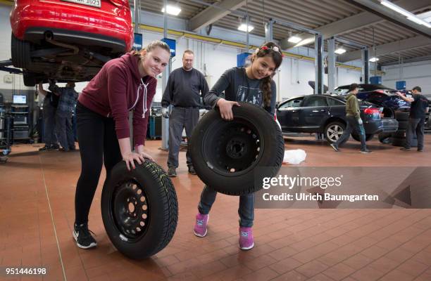 The Girls'Day - Girls Future Day, takes place annually since 2001. The photo shows the girls Lisa left and Dana with car tires in a car repair shop...