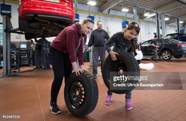 The Girls'Day - Girls Future Day, takes place annually since 2001. The photo shows the girls Lisa left and Dana with car tires in a car repair shop...