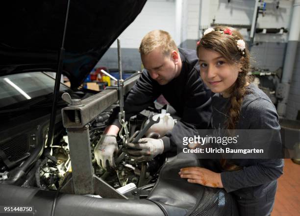 The Girls'Day - Girls Future Day, takes place annually since 2001.The photo shows the girl Dana and a technician at work on a motor in a car repair...