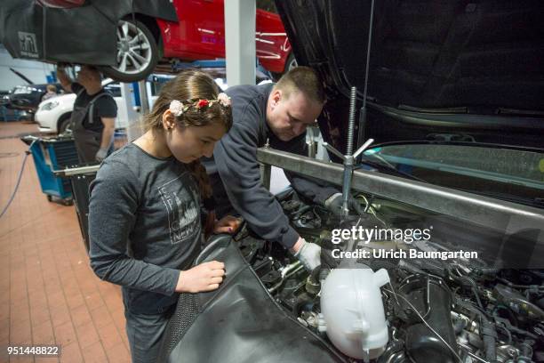 The Girls'Day - Girls Future Day, takes place annually since 2001.The photo shows the girl Dana and a technician at work on a motor in a car repair...